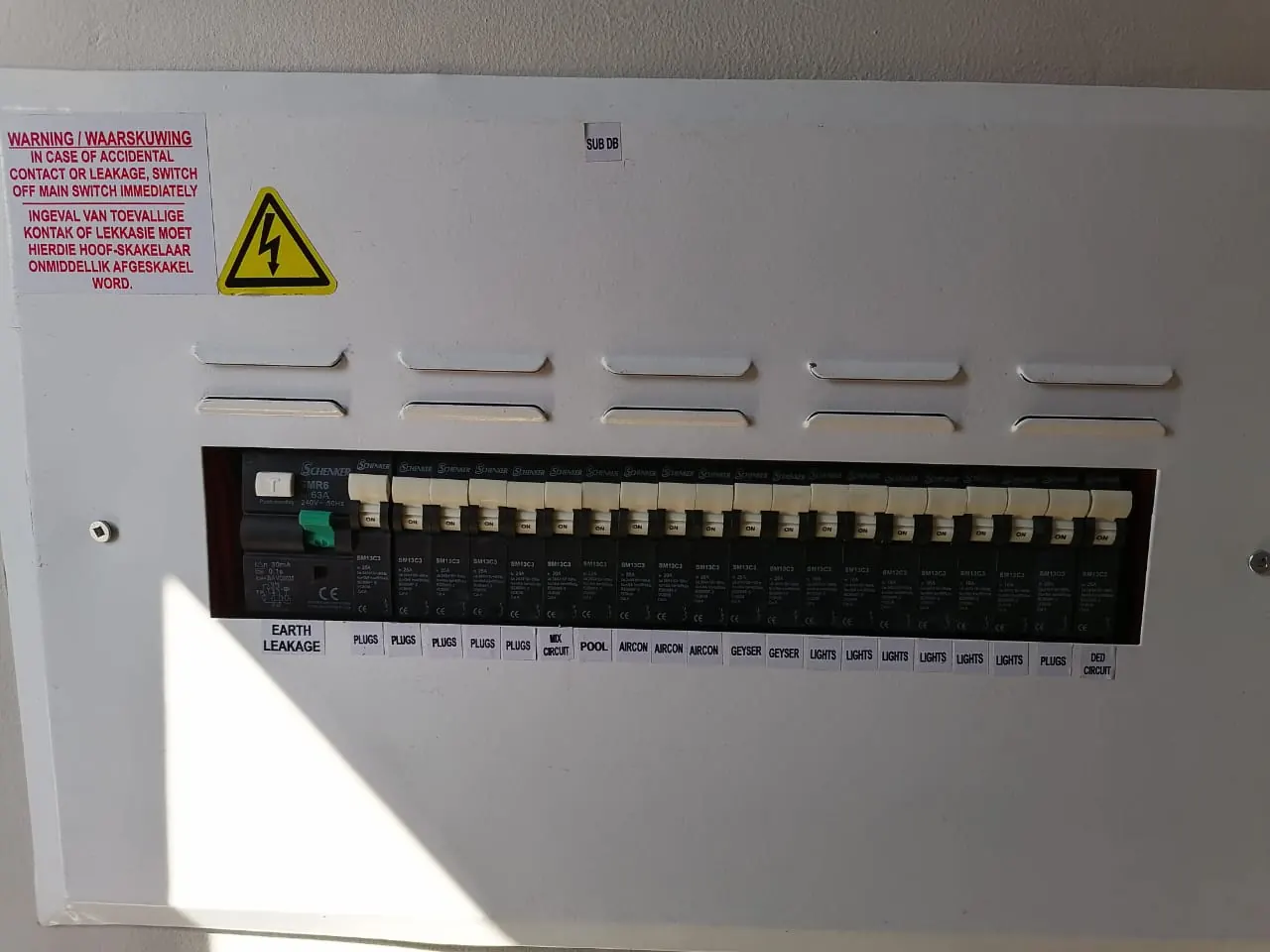 Closed distribution board with every circuit labelled and the warning notice fitted