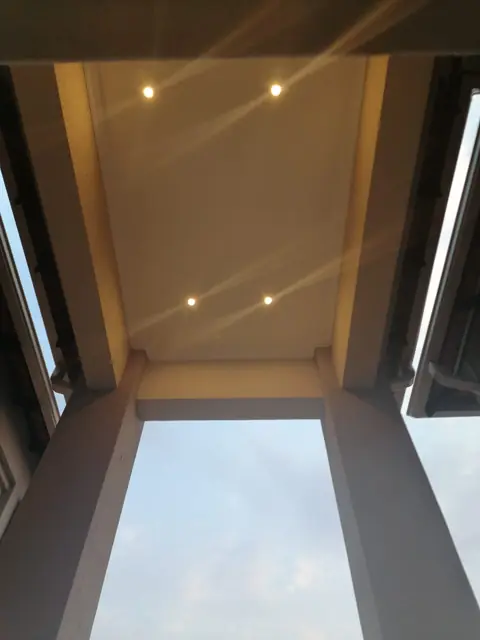 Recessed downlights either side of a skylight